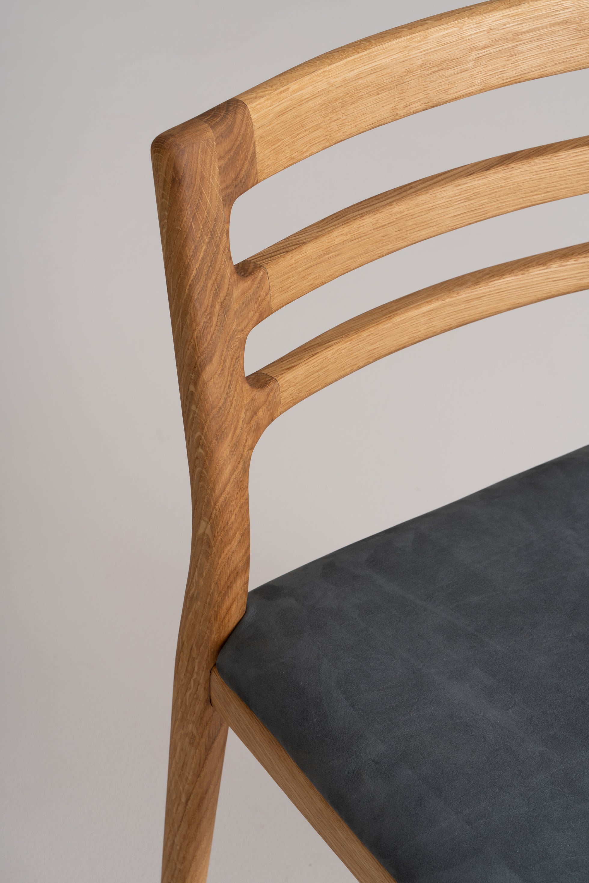 Upholstered seat in Italian leather or linen adds refined comfort.